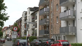 Eine Straße in der Bremer Neustadt mit Reihenhäusern in denen Einlegerwohnungen sind. Auf der Straße parken Autos.