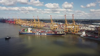 Ein Container-Schiff am Hamburger Hafen aus der Vogelperspektive zu sehen.