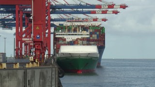 An dem Hafen liegt ein großes Containerschiff.