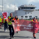 Menschen in gelben Warnwesten bei einem Demonstrationszug.