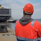 Ein Hafenarbeiter des JadeWeserPorts (JWP) in Wilhelmshaven (Niedersachsen) verfolgt das Anlegemanöver eines Containerfrachters