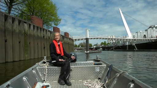 Eine Frau fährt in einem Motorboot durch den Vegesacker Hafen