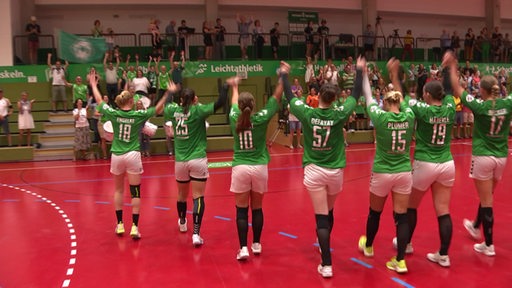 Die Werder Handballspielerinnen halte sich ihre Hände und lassen sich, nach ihrem Sieg, in der Halle feiern.
