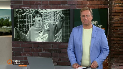 Der Moderator Stephan Schiffner vor einem Bild der verstorbenen Handballerin Sabine Adamik im Sportblitz-Studio.