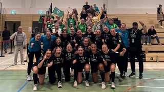 Werder Handballerinnen stehen vor ihren Fans und jubeln