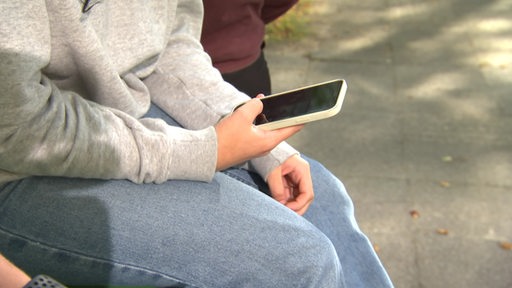 Eine Person hält ein Handy in der Hand