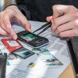 Techniker zerlegt altes Handy (Archivbild)