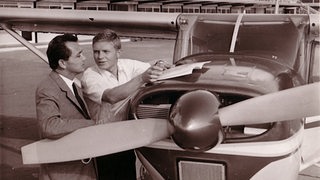 Hardy Krüger und sein Pilot prüfen die Flugroute vor ihrer Propellermaschine