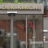 Das Eingangsportal eines Gebäudes, über dessen Tür der Schriftzug Haus der Kirche angebracht ist