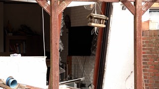 Eine zerborstene Fensterscheibe nach einer Explosion in einem Wohnhaus.