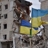 Ukrainische Flaggen wehen vor einem zerstörten Wohnkomplex in Orikhiv.