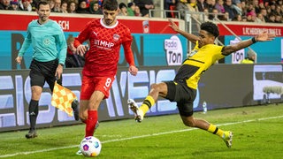 Eren Dinkci führt im Spiel gegen Dortmund den Ball. Dortmunds Maatsen will ihm diesen abnehmen.