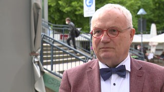 Der ehemalige Finanz-Staatsrat Henning Lühr trägt ein rötliches Sakko und eine blaue Fliege. Er soll die Geschäftsführung der Brebau interimsweise übernehmen.