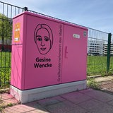 Ein pinker Stromkasten mit einem Gesicht drauf.