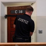 Ein Justizvollzugsbeamter schließt einen Häftling ein.