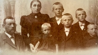 Ein altes analoges Familienfoto einer siebenköpfigen Familie.