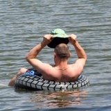 Ein Mann lässt sich in einem Schwimmring auf einem See treiben.