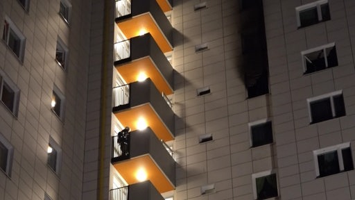 Ein Feuerwehrmann auf dem Balkon eines Hochhauses
