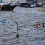 Ein Schild im Wasser warnt vor Flut.
