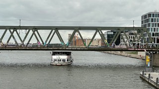 Ein Schiff stößt bei der Durchfahrt fast gegen eine Brücke.