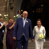 Der Bürgermeister und seine Ehefrau werden vor dem Rathaus mit Blumen empfangen.