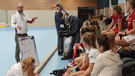 Der neue BHC-Coach Florian Keller erklärt am Rande des Trainings seines Spielerinnen etwas an der Taktiktafel.