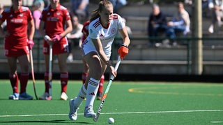 Hockey-Spielerin Lena Frerichs vom  Bremer HC läuft konzentriert mit dem Ball vor sich an zum Penaltyschuss gegen Köln.