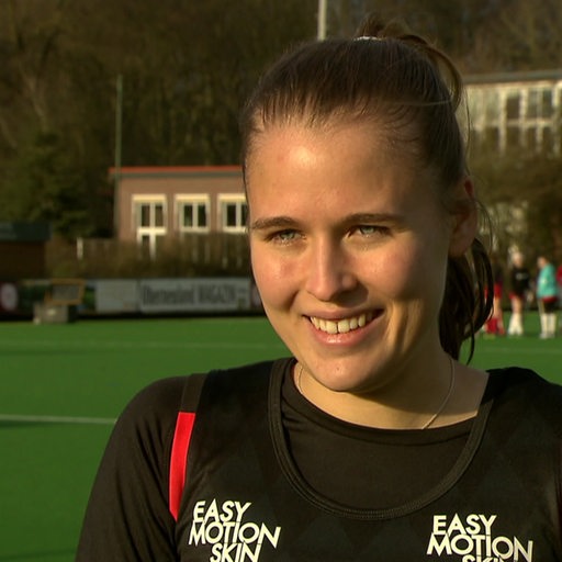 Hockey-Spielerin Lena Frerichs lächelt beim Interview nach einem Spiel.