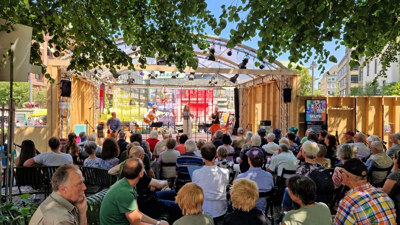 Ein Konzert mit Musikern auf der Sommerbühne in der Bremer City, im Vordergrund das Publikum. 