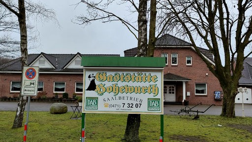 Das Schild "Gaststätte Hohewurth" steht vor einem Landgasthaus