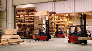 Gabelstabler lagern Holzbretter in einem großen Lager.