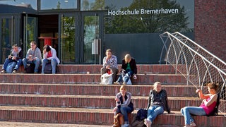Studierende vor dem Eingang des Erweiterungsbau der Hochschule Bremerhaven. 