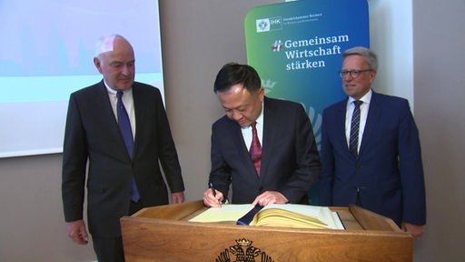 Der Vizebürgermeister von Shanghai, Hua Yuan beim Unterschreiben eines Dokumentes