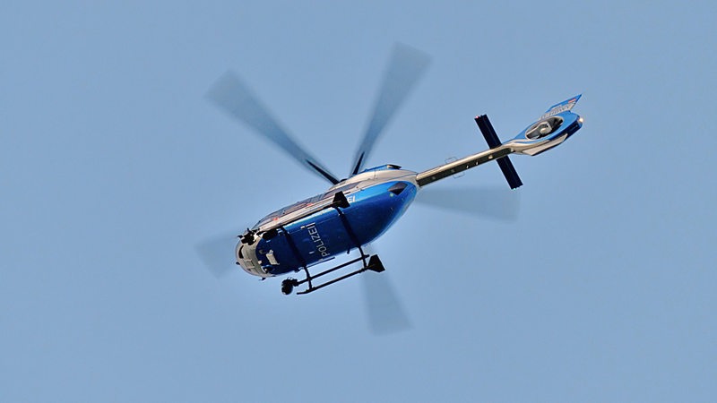 Ein Hubschrauber der Polizei fliegt am Himmel.