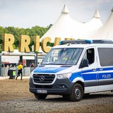 Ein Einsatzfahrzeug der Polizei fährt vor dem Gelände des Hurricane Festivals entlang. 