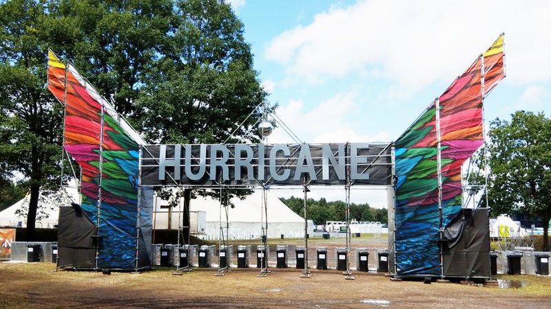 Der Eingang zum Hurricane-Festival ist dekoriert mit dem Schriftzug und bunten Flügeln auf der linken und rechten Seite.