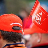 Ein Mann trägt eine IG Metall Fahne an seiner Gewerkschaftsmütze.