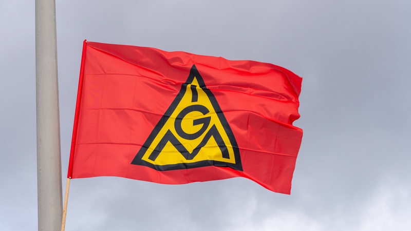 Eine rote Fahne mit IGM-Logo weht im Wind.