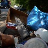 Müll liegt am Rand einer befahrenen Straße.