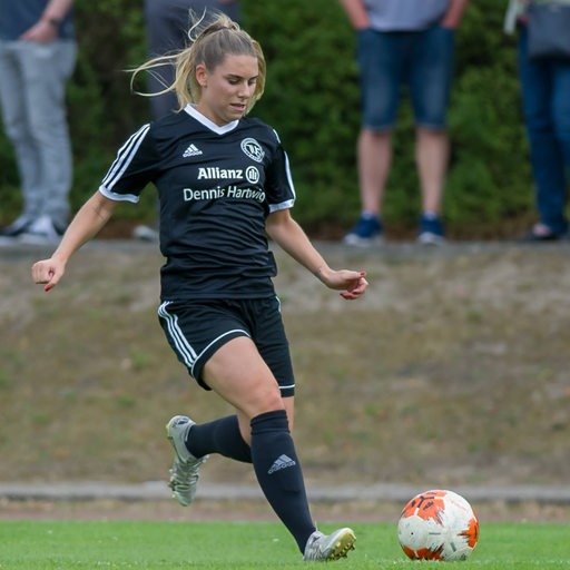 Schwachhausen-Spielerin Meggie Schröder dribbelt mit dem Ball die Seitenlinie entlang.