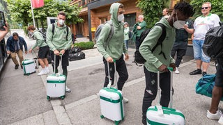 Werder-Spieler um Jiri Pavlenka und Lars Lukas Mai bei der Ankunft im Hotel im Zillertal mit ihren Rollkoffern.
