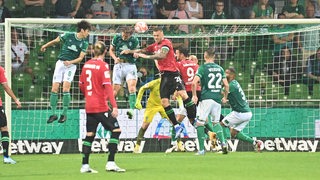 Werder-Spieler im Kopfballduell mit Hannoveraner Spielern. 