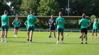 Werders Fußball-Frauen stehen um ihren Trainer Thomas Horsch im Kreis.