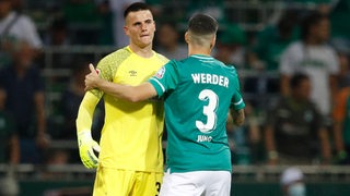 Werder-Torhüter Michael Zetterer klatscht sich nach Schlusspfiff mit Anthony Jung ab. 