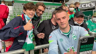 Marvin Ducksch macht ein Selfie mit Fans auf de Tribüne des Weser-Stadions.