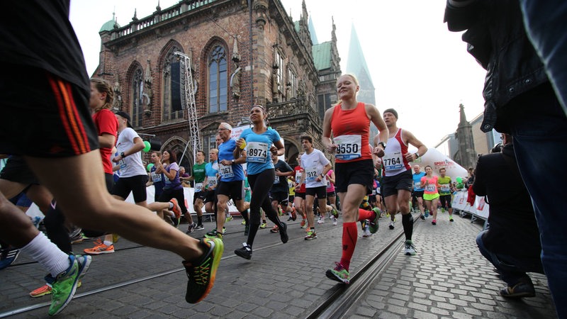 Läufer rennen am Bremer Marktplatz vorbei.