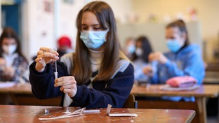 Schüler testen sich im Klassenzimmer auf das Coronavirus.