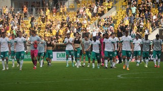Werder-Spieler traben enttäuscht über den Rasen in Dresden.