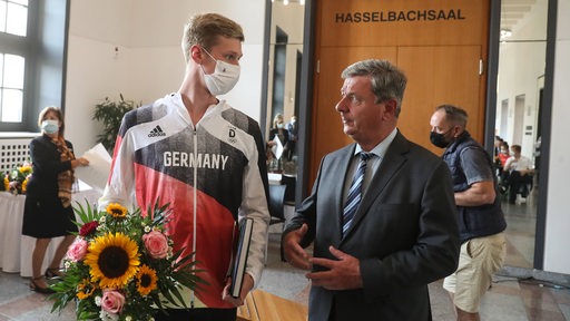 Schwimm-Olympiasieger Florian Wellbrock bei der Ehrung im Magdeburger Rathaus im Gespräch mit Oberbürgermeister Lutz Trümper.