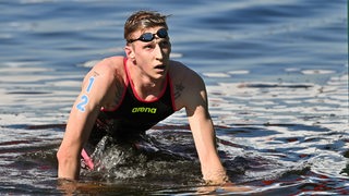 Der frisch gebackene Olympiasieger Florian Wellbrock krabbelt aus dem Hafenbecken.